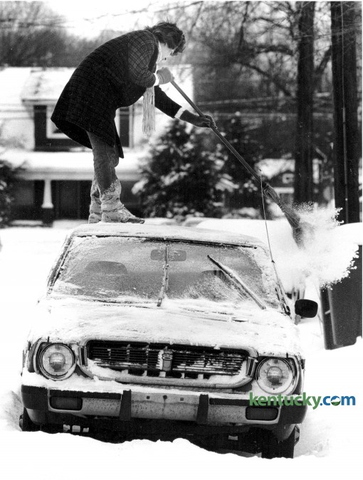 Valerie Wells swept the snow from the roof of her  car as it was parked on Kentucky Avenue February 2, 1985. Photo by Christy Porter, Herald-Leader staff