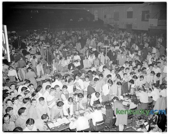 Upperclassmen wait around tables in men's gymnasium to register for University of Kentucky classes Sept. 1946.