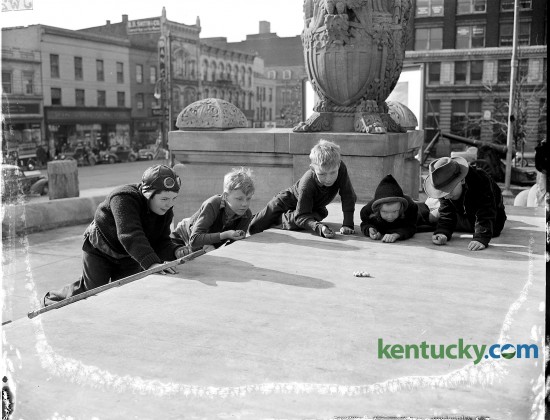 Children played marbles on the front steps of the Fayette Co. courthouse in March of 1942.  Pictured from left to right are Raymond Dunn, Bobby Carlberg, Jimmy Thomas, June Thomas, and Arthur Paul Hart Jr. The photo was published in the Lexington Herald March 7, 1942 with a story about spring arriving in Lexington.