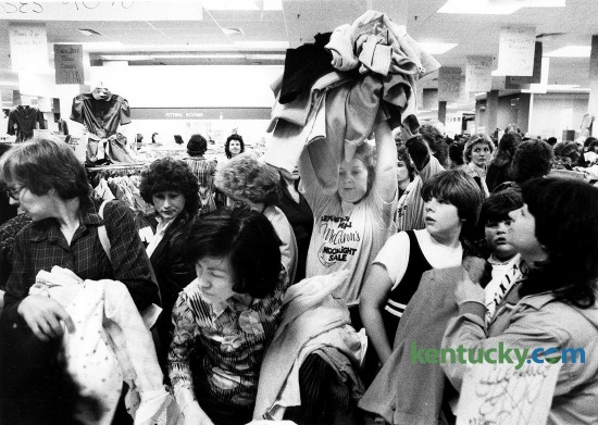 When the crowd at Lexington Malls' McAlpin's hollered during a moonlight madness sale for more clothes at discount prices of $1 and $2, Lolene Dawkins came to the rescue April 10, 1984. She would take clothes from another table and throw them over the heads of unsuspecting shoppers.  Photo by Steven R. Nickerson | Herald-Leader staff