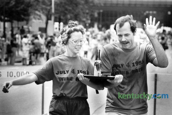 Martha LaFollette and Chuck Dean near the finish line to win the Waiter's Wine Race in downtown Lexington July 4, 1983. LaFollette and Dean worked for Joe Bologna's restaurant and placed second in 1982 and first in 1981. The race involved carrying a tray of filled wine glasses through an obstacle course while tied to a teammate. Photo by Gary Landers, Herald-Leader staff