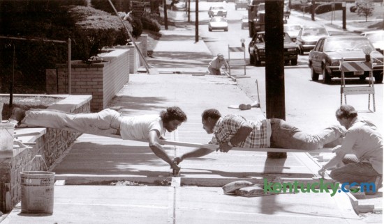 Paul Dunn, Tony Coffey and Freddie McCollum, employees of Jason Tate, Jr., a Lexington contractor, worked to finish concrete work on a new sidewalk on East Main Street August 19, 1987. Photo by Frank Anderson | Staff