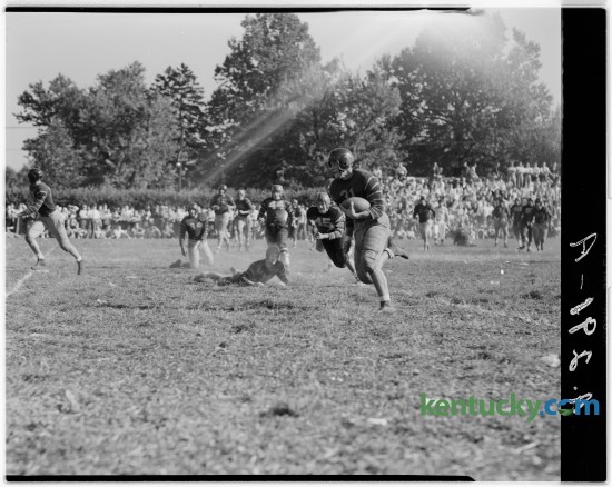 Gibson Downing, Henry Clay right end, scored a  touchdown in a game with Shelbyville in October of 1946.  Also shown in the picture are Henry Clay's Ray Current, on the ground looking up, and Shelbyville players Bill Green (44) and Charles Long (45). The game was played at Cassidy field. Published in the Lexington Herald October 5, 1946. 