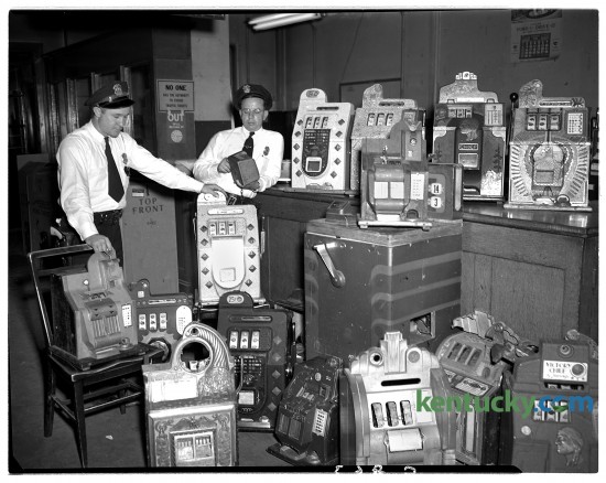 Lexington patrolmen Gilbert Hay, left, and Jesse Williams Jr. pictured Aug. 8, 1948 with slot machines seized in raid at 401 East High St.