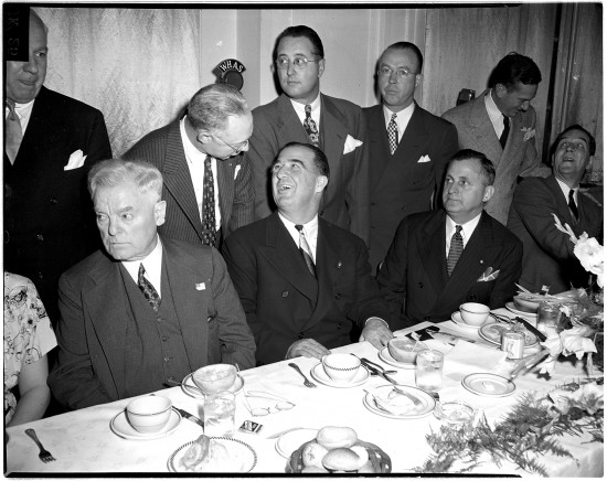 Above, the Lexington Co-Operative Club held a testimonial dinner to U.S. Sen. A.B. (Happy) Chandler in April 1945 at the Lafayette Hotel. Chandler was being honored as the newly appointed commissioner of major league baseball. Chandler is seated at the center of the table, turning his head to speak to a man standing behind him. Seated at right, next to Chandler, is Adolph Abraham, president of the Co-Operative Club. Standing, from center to left, are William E. Benswanger, president of the Pittsburgh Pirates; William DeWitt, general manager of the St. Louis Browns; and Earl Hilligan, representing Will Harridge, president of the American League. The identities of the other men in the photo are unknown.Chandler was twice governor of Kentucky and served in the U.S. Senate. He resigned his Senate seat to become the second commissioner of baseball. During his tenure, from 1945 to 1951, he approved Jackie Robinson’s contract with the Brooklyn Dodgers, helping to integrate baseball, and he established the first pension fund for players. Owners became upset with Chandler and did not renew his contract.  