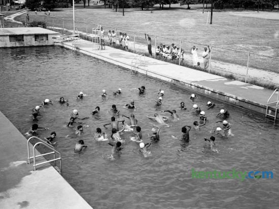 African-American swimming class at Douglas Park pool in July 1944. These girls, in that week's Herald-Leader classes at Douglas pool, were learning how to use their arms to reach out and pull themselves through the water.  In the center, demonstrating the strokes, are (left to right) Life Guard A.D. Burroughs, Head Instructor Lucian P. Garrett, Life Guard Morrison Jenkins and Assistant Instructor Leonard Mills Jr.  Published in the Lexington Leader August 3, 1944. Herald-Leader Archive Photo