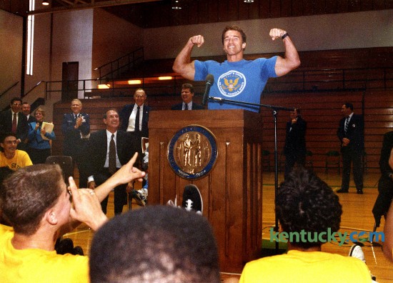 Actor Arnold Schwarzenegger, chairman of President George H. Bush's Council on Physical Fitness and Sports, flexed his muscles during a Sept. 24, 1990 visit to Bryan Station High School in Lexington. The actor was on a nine-state tour to promote exercise and good health. Schwarzenegger was Chair of the President's Council on Physical Fitness and Sports from 1990-93. At left, looking up at Schwarzenegger is Kentucky Governer Wallace Wilkinson.  Photo by Jennfer Podis | staff