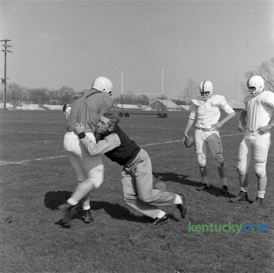 UK football coach Charlie Bradshaw, unhappy with the way blocking assignments were being carried out, demonstrated the technique on Paul Pisani, a sophomore from Decatur, Ala., at practice on April 17, 1962. Bradshaw was the UK football coach from 1962 to 1968 posting a record of 25–41–4.  