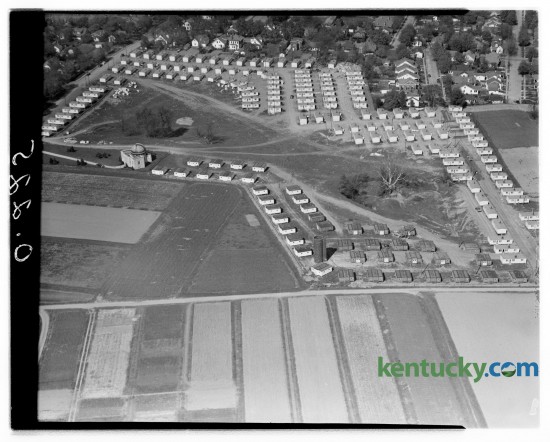 This aerial view shows approximately 250 of the housing units in Cooperstown, a temporary housing project being set up on the Experiment Station farm to house student veterans at the University of Kentucky.  Houses at the top left are located along Woodland Avenue and the row at the extreme right is located on the east side of an extension of Oldham avenue.  The University observatory, which serves as headquarters for the project manager, is shown at the left.  Seventy houses on Hill Top Avenue, which extends west almost to Rose street, are not included in the picture.  Eighty units are yet to be set up in the village. Kentucky Historical Marker paying tribute to Cooperstown, the graduate student housing area that was recently torn down to make way for new undergraduate housing Published in the Herald-Leader April 14, 1946. 