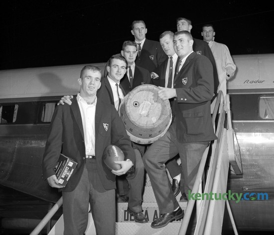 The Kentucky Wildcats arrived at Blue Grass Field Nov. 24, 1962 with the trophies of their 12-10 victory at Tennessee -  the game football and the Beer Barrel. The Beer Barrel would go to the winner of the annual game between the SEC schools. The blue and orange barrel resided at the home of the winning team from 1925 until 1998, when it was discontinued after an alcohol-related car crash involving Kentucky players. At the time it was retired, the barrel had been in UT’s possession since 1985. The players in the picture are, left row, bottom to top, Clarkie Mayfield, whose two field goals decided the game; Darrell Cox, who scored Kentucky's lone touchdown; Ray Heffington and Frank Sakal; right row, bottom to top, Herschel Turner, holding the beer barrel, Jim Hill, Jim Komara and Jerry Woolum.