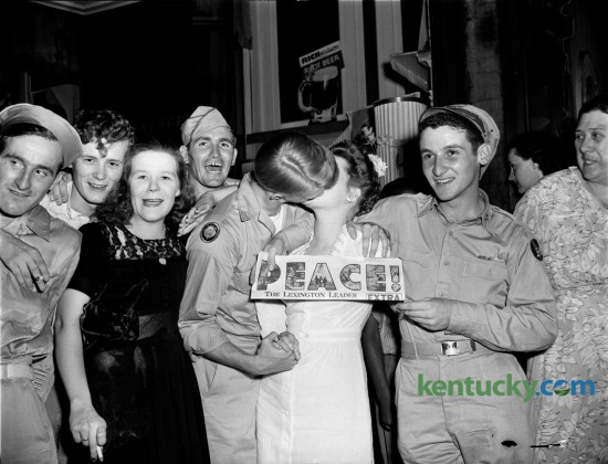V-J Day Celebration in Lexington, August 14, 1945.  Celebration in streets after Leader's extra hits the streets.  Woman holds up newspaper as returned European war veteran kisses woman he found in the crowd. Published in the Lexington Leader August 15, 1945.