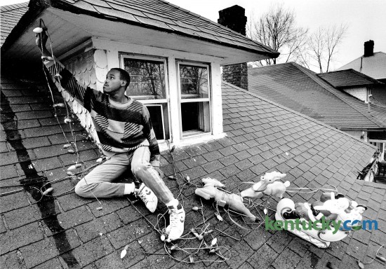 Jim Moore removed Christmas decorations from the roof of his home in Lexington at 148 East Fifth Street Jan. 2, 1989. The house and yard were filled with decorations and over 500 lights. Photo by Charles Bertram | Staff