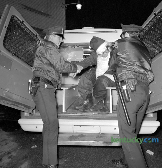 Two Lexington policemen assist an inebriated Santa Claus after he was arrested for public drunkenness Dec. 23, 1969.