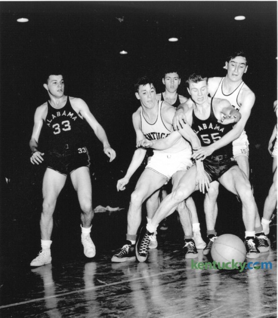 University of Kentucky's Alex Groza, center left and Wallace "Wah Wah" Jones, right, battled Alabama's Carl Shaeffer (55) for a loose ball in Alumni gymnasium February 16, 1948. The other Alabama players are not identified. UK won 63-33. That year's UK team, coached by Adolph Rupp, finished the season as World Champions (Olympic Games); National Champions; SEC Champions and SEC Tournament Champions. Leading scorers were Alex Groza, 12.5 ppg; Ralph Beard, 12.5 ppg; Wallace Jones, 9.3 ppg; James Line, 6.9 ppg; and Kenneth Rollins, 6.6 ppg. 
