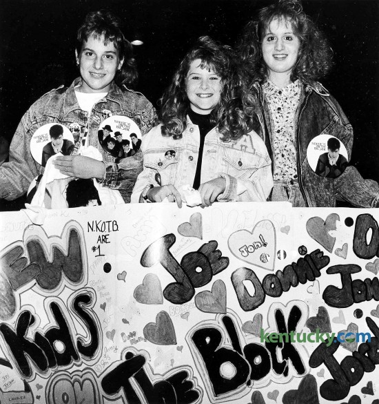 From left, Laurie Beaven, 12, Amy Lanham, 12, and Melissa Gordon, 13, wait for the begining of the New Kids on the Block concert to begin Jan. 13, 1990 at Rupp Arena. The trio came from Spingfield and brought the homemade banner with them. With parents in tow, young girls wearing New Kids on the Block T-shirts, jackets, buttons, hats and bandanas flooded the Lexington Civic Center, waiting to get in to see the popular singing group. They paid at least $18.50 apiece for the opportunity. At the time of this nearly sold-out show of 21,000, the group had vaulted to teen stardom with three hits -- "This One's for the Children," "Cover Girl" and "Didn't I (Blow Your Mind)." The first two numbers of the New Kids' 90-minute concert -- "My Favorite Girl" and the beat-crazy "What'cha Gonna Do About It" -- were almost totally drowned out by the crowd, which shrieked and shrilled at every move the group made. Just how loud was the crowd? Well, let's put it this way. Earplugs were being sold at the concession stands. Photo by James D. VanHoose | staff