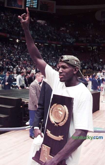 Kentucky basketball sharpshooter Tony Delk held the championship trophy April 1, 1996 after the Cats victory in the  NCAA Tournament Championship game in East Rutherford, N.J. UK defeated Syracuse 76-67 behind Delk's 24 points. Delk, the Final Four's Most Outstanding Player, tied a championship game record with seven three-pointers. The win gave the Wildcats their sixth national title. On Feb. 22, 2015, Delk became the 43rd men's basketball player to have their jersey retired by UK. Photo by Charles Bertram | Staff