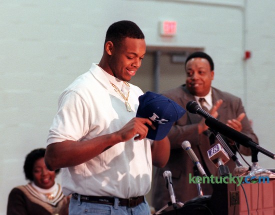 Dennis Johnson put on a University of Kentucky hat on after the announced that he would sign with the Wildcats to play football durning a signing day press conferenace Wed. Feb. 4, 1998 at Harrodsburg High School. Johnson, the state's Mr. Football and USA Today National Player of the Year, choose UK over Notre Dame, Florida, Miami and Colorado. "The fact I can play right away had a lot to do with it," Johnson said at the press conference that went on despite 11 inches of snow blanketing Central Kentucky that snarled roads and closed schools and businesses  "I think I could have played early at Notre Dame, too. But Kentucky's got some good recruits coming in, and they'll definitely be a better defense next year than they were last year." Said UK recruiting coordinator Claude Bassett, "In most everybody's eyes, and certainly in our eyes, he's simply the best defensive football player in the country." Johnson played three years at UK, and was a third-team All-American and first-team All-Southeastern Conference. He left UK early to enter the the NFL draft and played in the league for three years. At left is his mother Rosetta Johnson at right is his father at coach Alvis Johnson. Phot by Frank Anderson | staff