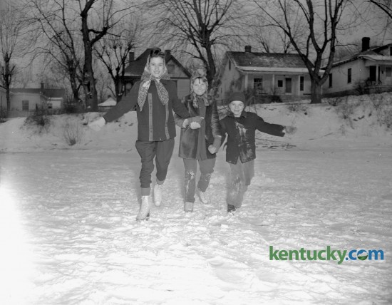 Barbara Horrell, 11, daughter of Mr. and Mrs. Floyd Horrell, Greta Kelly, 10, and Charles Kelly, 7, the  children of County Patrolman and Mrs. Leo Kelly, tried ice skating on a snow covered Clifton pond in February, 1947. Clifton Pond, located in Clifton Heights was platted around the turn-of-the-century between the city of Lexington and the A&M College of Kentucky (now UK). This old Lexington subdivision, was razed in the 1990's for the construction of UK's W.T. Young Library. 