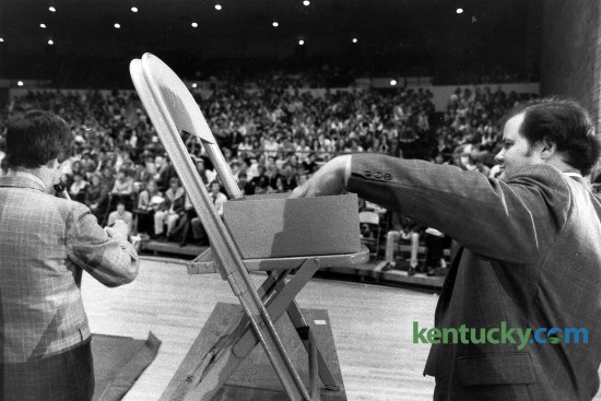 University of Kentucky Dean of Students Joe Burch, left, reads winning numbers during a basketball ticket lottery as Bob Clay drew from from the pool of enteries March 9, 1982 in Memorial Colesium. 2,000 UK students entered into the lottery for 200 tickets to a possible matchup between Kentucky and Lousiville in the second round of the NCAA Mideast Regionals in Nashville. However, it never happened because the Cats were upset in their opeing round game, 50-44 by Middle Tennessee St. Burch said the lottery system was used in the past but that there was more interest this time because of the prospect of playing U of L, the proximity of Nashville and the fact the students will be on spring break the next week. He said UK put in as many safeguards as possible to prevent students from scalping tickets. "We don't want people to come in here and get those tickets and later sell them," Burch said. Students who paid $20 a ticket at the lotterty got vouchers that will be turned in at the game site. Students must have validated ID cards to get the tickets. Photo by David Perry.