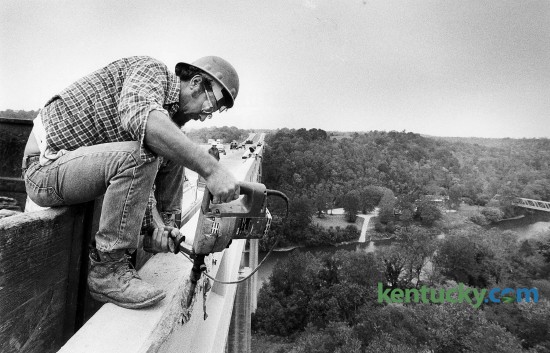 Carlos Wall has a bird's eye view of the Kentucky River as he uses an electronic chipping hammer on the Interstate 75 bridge at Clays Ferry Oct. 4, 1983. The northbound lanes were being repaired and in this case, one lane was not open as Wall was removing some bulging concrete from the wall. Photo by Charles Bertram | staff