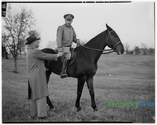 Steve Black, left, of Frankfort, presented a ribbon to Colonel Carl W. Raguse up on El Foxo, who received a blue ribbon in the open jumping class during the Iroquois Hunt Club horse show at W. Fauntleroy Pursley's farm on Athens-Boonesboro Road October 12, 1946.  The club's horse show included a horse pulling contest and beef barbecue. Published in the Herald-Leader October 14, 1946. 