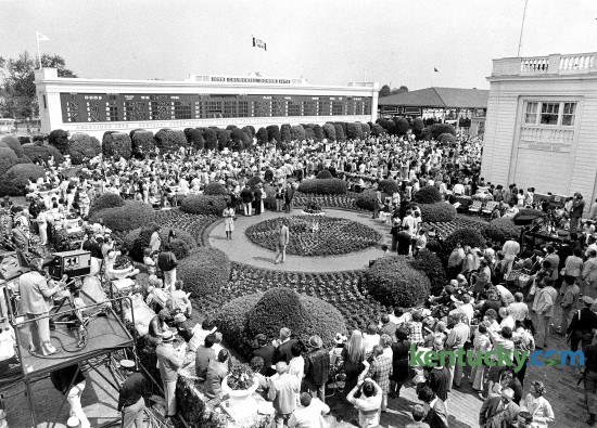 View from behind the clubhouse of the Churchill Downs garden on Derby Day, May 1, 1976. The paddock can be seen towards the upper right side of the photo. Ten years later, Churchill Downs, which was in the midst of a $25 million renovation, opened its fall meet with a $2.6 million paddock- toteboard complex behind the clubhouse that is used today. The renovation included 20 red-oak paneled stalls in a saddling facility. The old paddock was converted into a pavilion with a seating area. The improvements were intended to make the track more competitive with other tracks and forms of entertainment, as well as more attractive for television coverage. In the old paddock, not all of the horses could always be seen. Today, the garden includes a statues of jockey Pat Day and Aristides, the horse that won the first Run for the Roses in 1875. Photo by Ron Garrison | staff