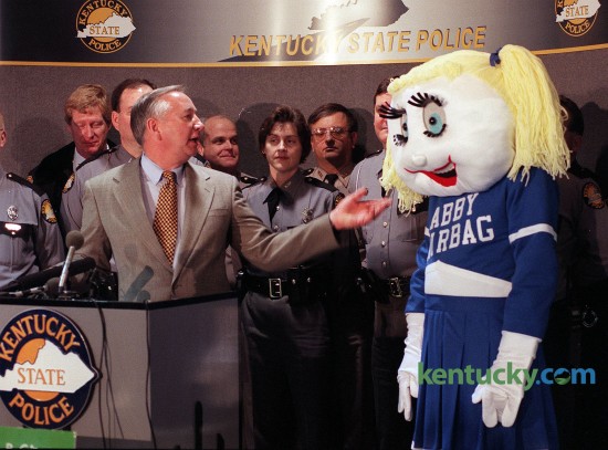 Jerry Lovett introduces mascot “Abby Airbag” during airbag an safety awareness press conference Feb. 11, 1997 in Frankfort. Kentucky State Police – along with the Chrysler Corp., the American Automobile Association and the American Academy of Pediatrics – unveiled a public education campaign that children should sit buckled up in the back seat when they ride in vehicles equipped with air bags. Abby Airbag,” a safety mascot dressed in a Kentucky blue and white cheerleader skirt and saddle shoes, will help spread the message at schools and day care centers. Tina Cox, program manager with the Kentucky State Police Highway Safety Standards Branch, came up with the idea for “Abby Airbag” while taking a shower one morning before work. Cox’s husband Rusty, who is a firefighter, put his wife’s thoughts on paper and the sketch was sent to a West Virginia company that makes mascots for colleges and universities. One month and $1,600 later and Kentucky has its own spokesperson to spread the word about air bag safety. Photo by Mary Annette Pember | staff file photo