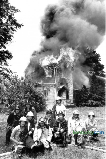 A group of firefighters pose in front of a burning house in rural Fayette County during a fire school exercise on June 2, 1981. The 86th Annual Kentucky State Fire School is in session in Lexington this weekend, June 3-7 where more than 1,200 firefighters and first responders are in attendance. Photo by Charles Bertram | Staff