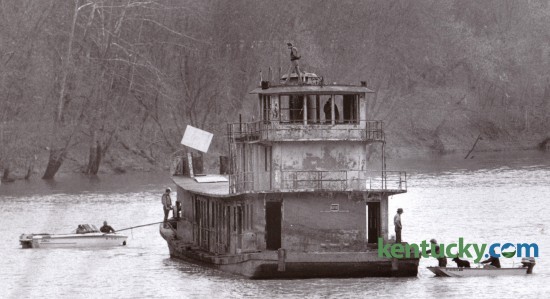 Two small boats helped maneuver a larger boat down the Kentucky River near Boonesboro November 18, 1986. The larger vessel had been submerged for nearly a decade and was raised and moved by Eddie Carter of Winchester. Carter planned to refurbish the boat. Photo by Gary Landers