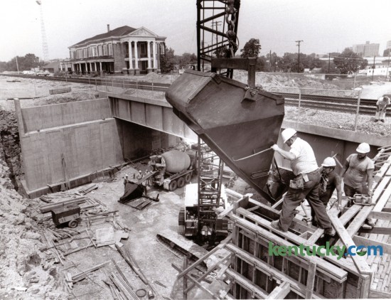 Adrian Surber, an employee of R.R. Dawson Bridge Company, Bloomfield, Ky., maneuvered a bucket holding concrete into position during construction of a bridge abutment for the South Broadway railroad underpass, August 8, 1985. Photo by David Perry | Staff