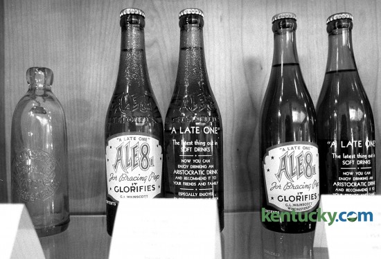 A display of Ale-8-One bottles in the lobby of the Winchester plant, July 2, 1990. The bottles shown are returnable bottles that were used from 1940-1959. According to spokeswoman Samantha Jackson, the company isn't sure why they chose "It Glorifies" on the front label but there are many differing opinions. That saying was last used on a returnable bottle in 1983. The current returnable bottle features the nutrition information on the reverse. Eighty-nine years after it was introduced at the Clark County Fair, Ale-8-One's packaging and branding is getting a 21st-century update. Photo by Stephen Castleberry | staff
