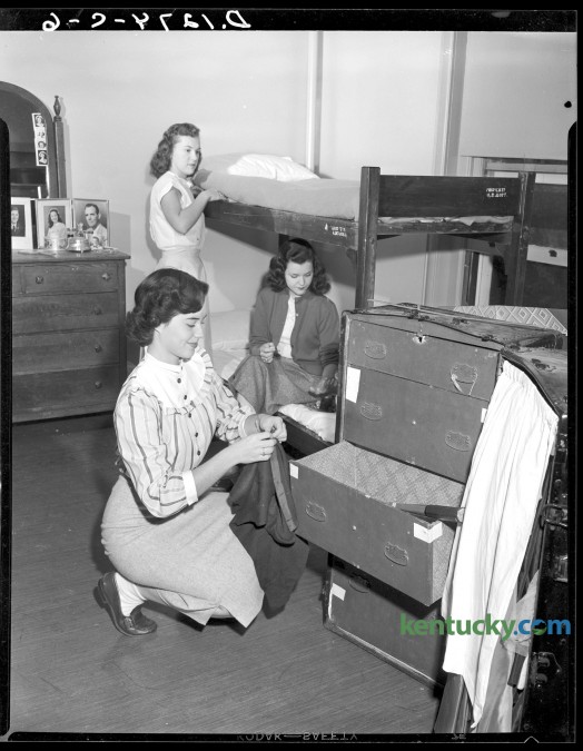 University of Kentucky students move into their dorm room in Patterson Hall during orientation week activities, Sept. 1949. Pat Moore, foreground, unpacks,  Marian Ferguson, rear,  made up her bunk and Mary Jo Cundiff applied polish to her nails.  Published in the Herald-Leader September 18, 1949. Herald-Leader Archive Photo