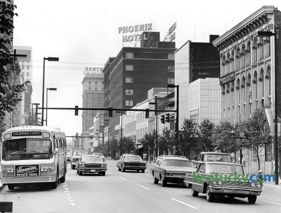 Traffic on Main Street in downtown Lexington, June 11, 1976. The photo was taken from Cheapside street looking east. The Phoenix Hotel was demolished in 1981 and 1982 by Wallace Wilkinson, who had planned to build the World Coal Center skyscraper on the site. It was never built, and the site eventually became the Park Plaza Apartments and Phoenix Park.  Photo by Frank Anderson | staff