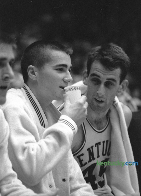 Kentucky's Louie Dampier, with cup, took a seat on the bench next to teammate John Adams (45) after scoring 37 points against Iowa State in Memorial Coliseum December 9, 1964 as the Cats won 100-74. Herald-Leader Archive Photo
