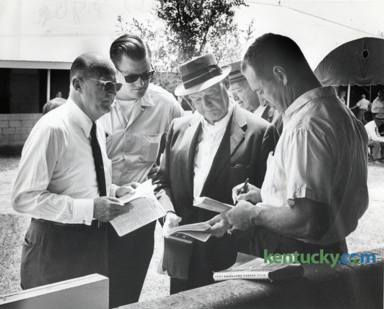 Looking over the sales catalog at Keeneland in July of 1963 are Leslie Combs II, founder and owner of the Spendthrift Farm, Brownell Combs, Leslie's son, John S. Knight, then owner of the Knight Newspaper chain which would later include the Herald-Leader, and an unidentified horseman. The two day Summer Yearly Sale was held on July 22-23, 1963.  The Keeneland November Breeding Stock Sale begins today and runs through November 13. Herald-Leader Archive Photo