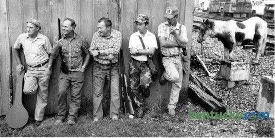 Taking shelter from a heavy rain at the Mt. Sterling Court Days on October 20, 1985 are, from left, Milford Bivens, Flemingsburg, Tony Wainscott, Lawrenceburg, Gene Gregory, Stamping Ground, Shelby Burgin, Richmond and John Fortune, Mt. Sterling. The annual gathering started in 1794 and took place when the Circuit Judge came to town to try criminals. People came from miles around to sell crops, trade horses and mules and other farm animals as well as swap goods and services. Guns and knives were among the top items traded. It continues to be one the largest outdoor festival in Kentucky. Photo by Gary Landers