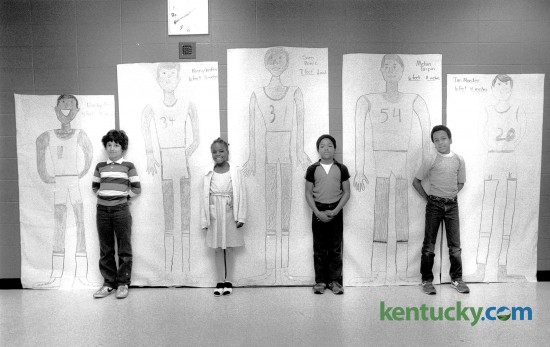 Picadome Elementary students, from left, A.J. Petrucelli, Tanya Pass, Issac Coffey and Mark Patterson, posed with live-size drawings of University of Kentucky basketball players on April 3, 1984. The players, from left are, Dicky Beal, Kenny Walker, Sam Bowie, Melvin Turpin and Jim Master. Photo by Charles Bertram | Staff