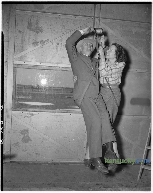 F. R. Wilson, a Lexington inventor, demonstrated a portable fire escape with the help of Mrs. James Wells, a Bohmer Flying Service employee in January 1947. Wilson, an representative of the Imperial Brass Manufacturing Company in Chicago, said the  5 pound device is a foolproff escape gadget which compressed in a package no larger than a shoe. It consisted of 200 feet of steel cable 3/32's of an inch thick, a spool on which the cable is wound, a seat harness and a breaking mechanism which had a capacity of 900 pounds. Published in the Lexington Leader January 21, 1947. Herald-Leader Archive Photo
