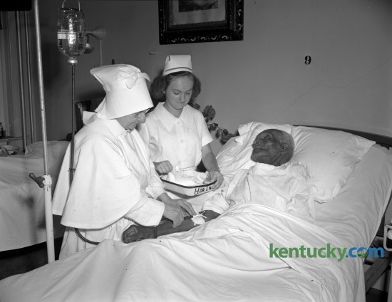 Monroe Smith, a former slave who was born August 15, 1848, on a farm near Bardstown, was a patient at the St. Joseph's hospital, where he was admitted for treatment for a chest condition in August 1947. With Smith are Sister Agnes Sienna and nurse Beaturice Chumley. Smith, who was owned by a Hill family, grew up as a field laborer and remembered that he was hoeing corn when the news of Lincoln's election to the presidency came. Because the Hills were so kind to their slaves, many stayed on even after they were freed, Smith said. He left after four years and worked as an odd-job man around Bardstown until he was hired as a gardener by the Sisters of Charity of Nazareth. Smith says he never married because "whenever I should have been out courtin' I was hiding stock and farm produce to keep them from the Rebel and Yankee armies."  Published in the Herald-Leader August 17, 1947. Herald-Leader Archive Photo