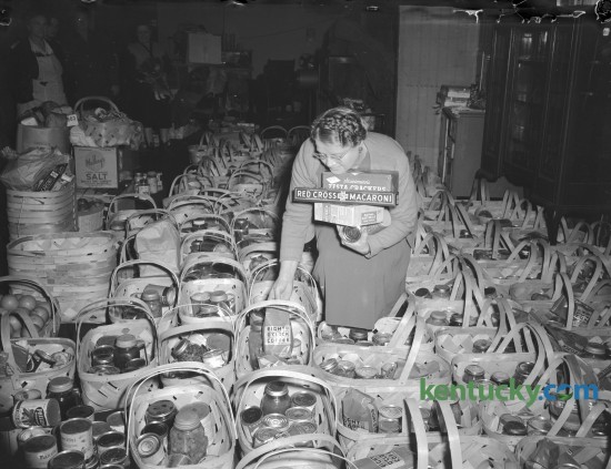 Mrs. Roy Jennings, 370 Bucoto Court, shown filling one of 400 baskets of food collected by Goodfellows Club of Everybody's church. Published in the Lexington Herald-Leader December 23, 1945. Herald-Leader Archive Photo