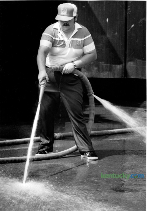 Sanford Vice, a driver for Domino's Pizza at Arcadia Park and Nicholasville Road, had a job on his hands July 24, 1986 as he tried to deal with a hose that wanted to spray in two directions at once. He was cleaning the parking lot in front of the business. Photo by Jim Wakeham | Staff