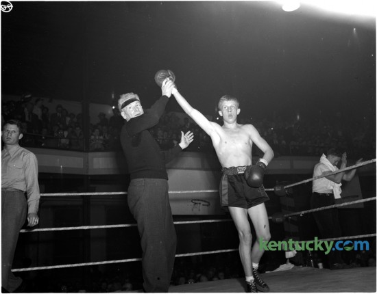 Aloft went the snappy right hand of Jimmy Barrett, lifted by referee Charley McCarthy on February 3, 1948, after the Lexington boy punched out a decision in four rounds over Archie Ware of Shelbyville to win the state open featherweight title and become the first Open champion crowned in The Herald-Leader Golden Gloves tournament at Woodland auditorium.  The featherweight king won a chance to compete in the national Golden Gloves tourney through his victories here. Published in the Lexington Leader February 4, 1948.