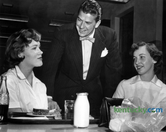 Screen and TV star Ronald Reagan met some of the employees  at the Lexington Lamp Works,  201 Rosemont Garden, during a tour of the plant  on Friday night, March 25, 1955. Here Reagan chats in the lunchroom of the  Lexington Lamp Works with Gretchen Boone (left), final inspector of  headlamps, and Bettye Watts, a tapper. A.D. Dixon was the plant manager at  the time. Reagan was the program supervisor of the General Electric Theater television series and came to Lexington  to visit two GE plants. He had breakfast that Friday morning at the Campbell  House with executives of the General Electric Co. and the Lexington  Herald-Leader. Photo published on Sunday  March 27, 1955. Photo by  E. Martin Jessee | Staff