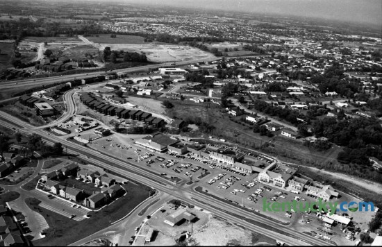 Aerial view of the Lansdowne Shopping Center in August of 1973. Tates Creek Road runs diagonally near the bottom of the photo, while New Circle Road is seen cutting left to right in the top third of the image. A portion of the Merrick Place Apartments is at the lower left. Some of the businesses occupying the shopping center, from right to left, included, Lansdowne Exxon, The Lansdowne Shoppe liquor store, Norgetown Laundry & Cleaning, Big B Cleaners, Henri's Fashions, First Federal Savings & Loan, Governor's Table restaurant, Begley Drug Company, First Security National Bank and Trust Company, Hallmark Colony of Cards, Pet Gallery, Lexington Academy of Dance, Stretch & Sew Fabrics, Angelucci's men's ware, Gingiss Formalwear, Lansdowne Florist, Line and Shot sporting goods, Lansdowne Veterinary Clinic, Lexington Travel Center, Lansdowne Barber Shop, Timothy beauty salon, Baskin-Robbins Ice Cream, and the A&P grocery store. Photo by  John C. Wyatt | Staff