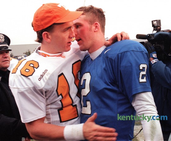 Tennessee's Peyton Manning and Kentucky's Tim Couch, after the Volunteers 59-31 win over the Cats, Nov. 22, 1997 at Commonwealth Stadium in Lexington. The much-hyped game featured the two quarterbacks - both with Heisman aspirations - combining to throw for 1 yard short of 1,000 yards. The game had 42 plays of 10 or more yards, 21 plays of 20 or more, 11 plays of 30 or more, seven plays of 40 or more, five plays of 50 or more, three plays of 60 or more. There were 1,329 yards of total offense. There were 57 first downs, 12 touchdowns and 90 points, 59 by Tennessee and 31 by Kentucky. The winning quarterback, Manning, trying to win the Heisman Trophy, threw for 523 yards and five touchdowns. The losing quarterback, Couch, hoping to win a future Heisman, threw for 476 yards and two TDs. Manning, a senior, was a perfect 11-of-11 for 267 yards and two touchdowns in the second half. His 523 passing yards set a UT school record. Tennessee's 695 yards of total offense were the most ever against a Kentucky defense. "Peyton just picked us apart, basically," said UK senior defensive end Lamont Smith. Not that Couch was crummy in comparison, mind you. The UK sophomore star completed 35 of 50 passes for a school-record 476 yards. Said Kentucky coach Hal Mumme, "I enjoyed watching both quarterbacks." Photo by David Stephenson | staff
