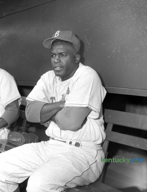 Brooklyn's Jackie Robinson shivers in the dugout as the Brooklyn Dodgers played the Milwaukee Braves in an April 9, 1956 preseason game in Louisville. The temperature was 44 degrees at game time at Parkway Field. The California native joked, "Now I know why they call it blue grass. It's frozen!" This was the beginning of the 37-year-old Robinson's last season in professional baseball. Published in the Lexington Herald April 10, 1956. Herald-Leader Archive Photo