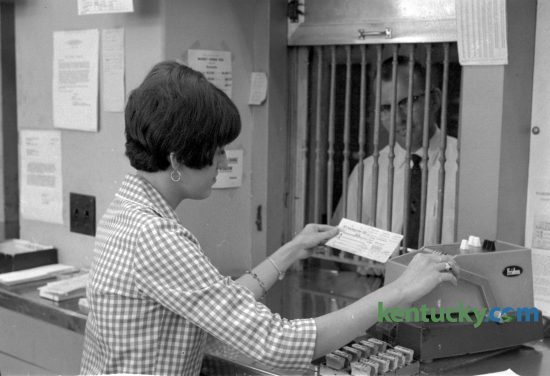 Suzanne E. Hudson helps a customer in the Lexington Post Office in September 1966.  Hudson became the first female window clerk to work at the office since 1952.  She was among 27 women employees, including two carriers, several clerks, stenographers, and secretaries. In 1960, there were only six women with the post office. Photo by John C. Wyatt | staff