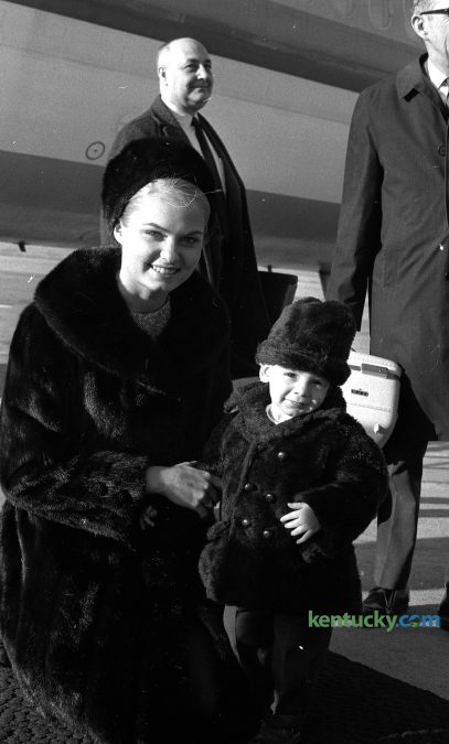 18-month-old Gregory Popan of Hazard greets Miss America 1969 Judith Anne Ford when she got off the plane at Blue Grass Field, Feb. 20, 1970. Popan was at the Lexington airport to greet his grandparents when he stumbled upon the beauty queen. Ford was in town to be the master of ceremonies for the Miss University of Kentucky pageant. Published in the Lexington Herald and The Lexington Leader, Feb. 21, 1970.