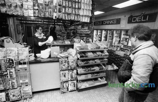 Interior view of a SuperAmerica convenience store on Winchester Road in Lexington Feb. 10, 1987. Some of the items for sale above the counter include film and flashes for cameras. To the right is a display of candy bars that include Hersey bars, M&M's and Snickers just to name a few. On the bottom and right side of the counter are such magazines as People, TV Guide and Sports Illustrated, which features Kentucky-native Phil Simms on the cover after his win in Super Bowl 21. In 1997 after the merger of Marathon and Ashland Petroleum, many SuperAmerica stores across the nation were renamed Speedway. In 2011 Marathon sold its SuperAmerica stores. Today Speedway and SuperAmerica are unrelated chains. Most of the SuperAmerica's are located in the midwest. Photo by Steven R. Nickerson | staff