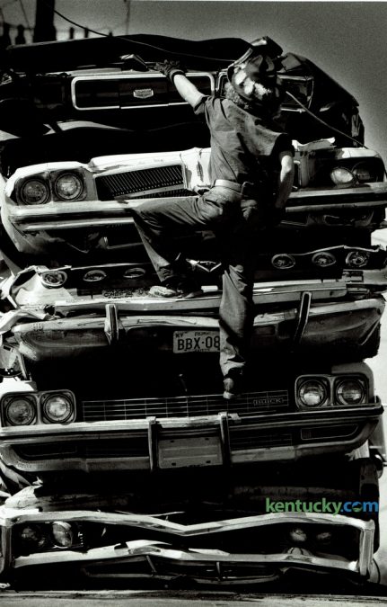 Donald Baker, with Baker Iron and Metal on Manchester Street, climbed up a stack of crushed autos on September 28, 1981. The cars were on a flat bed truck and he was securing them with a cable before being taken to a recycling center out of state. Photo by Ron Garrison | Staff